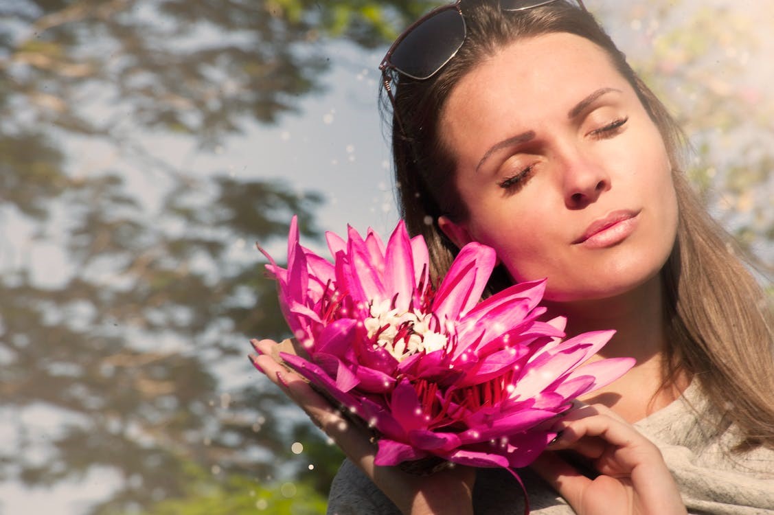 A girl with a pink water lily flower